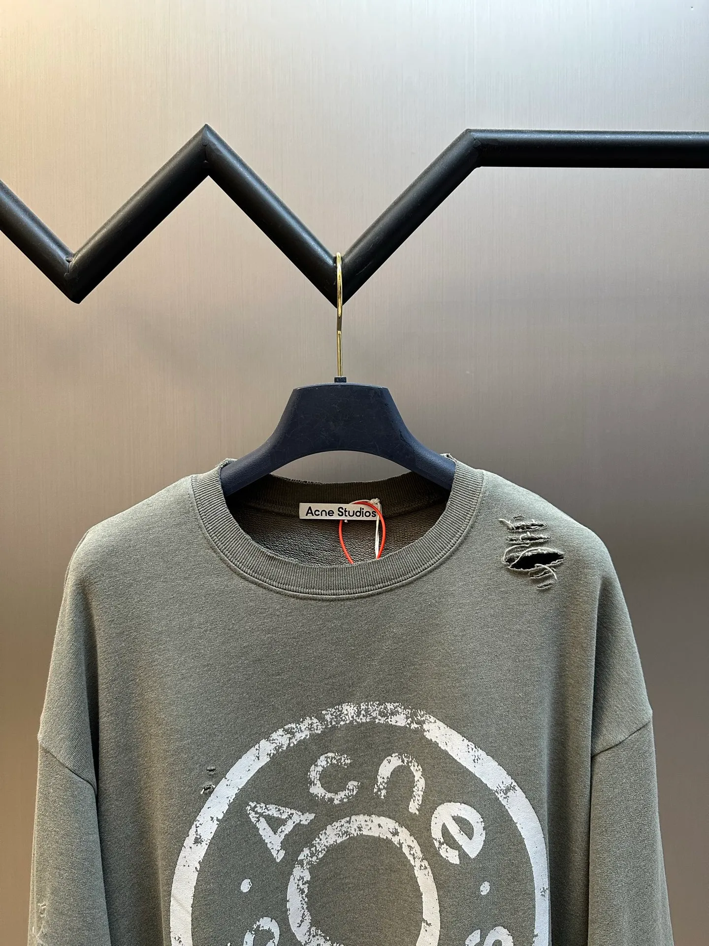 Ac Studios ripped distressed logo sweatshirt, custom dyed 1:1 gray green soft cotton sweatshirt material, the top fabric and terry bottom are the same color configuration, the market fabric In Stock has a different color on the top and bottom, which does not match the original! The minimum order quantity of fabric is 2 tons, and the fabric manufacturing process alone takes 45 days! The unruly soul of Ac Studios is engraved on the chest. The ingenious integration of hole elements and wanton swaying on the Gray canvas is a deliberate rebellion and a break away from the shackles of tradition. It is unique in the wave of the trend. It uses glue printing. The chest printing has been modified three times with the film screen. The glue liquid paint is used to print the pattern on the fabric, and the fabric is baked to fix the printing pattern. Many parts of the body of the garment are frayed and worn at regular intervals by purely artificial means, and marks are manually brushed to add texture and depth to the surface of the garment to imitate the texture of natural wear and tear. size：s m l xl